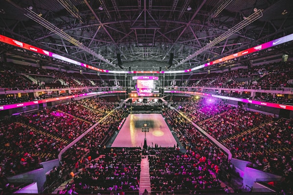篮球赛场全景，明亮的灯光照耀着木质地板球场